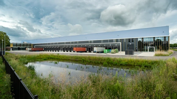 Industrial property with multiple truck bays near a grassy pond