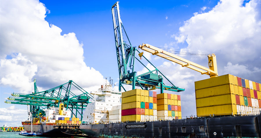 Image of a port dock with colorful shipping containers and cranes