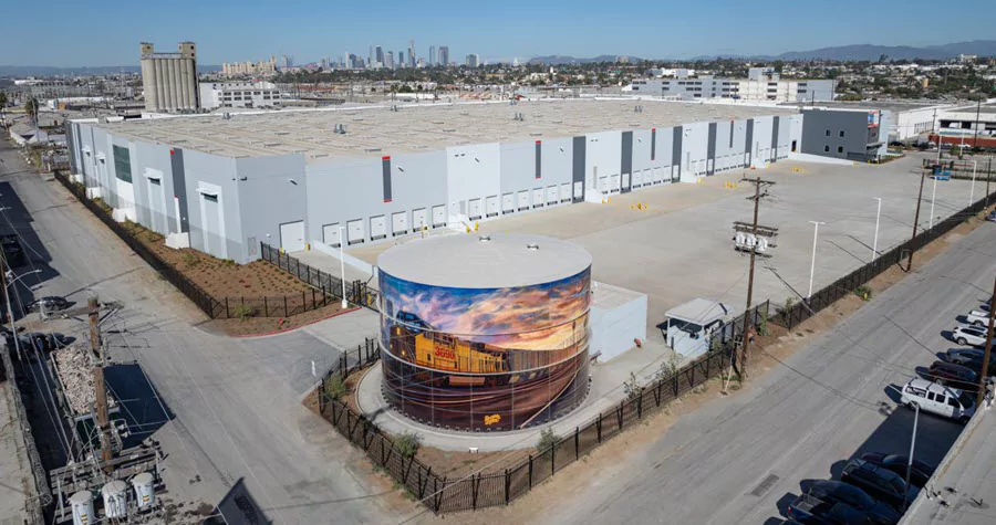 Large industrial complex with a painted water tower in the foreground