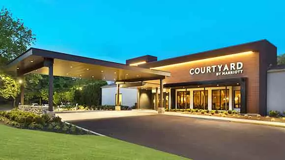 Courtyard hotel entrance with green grass and blue sky